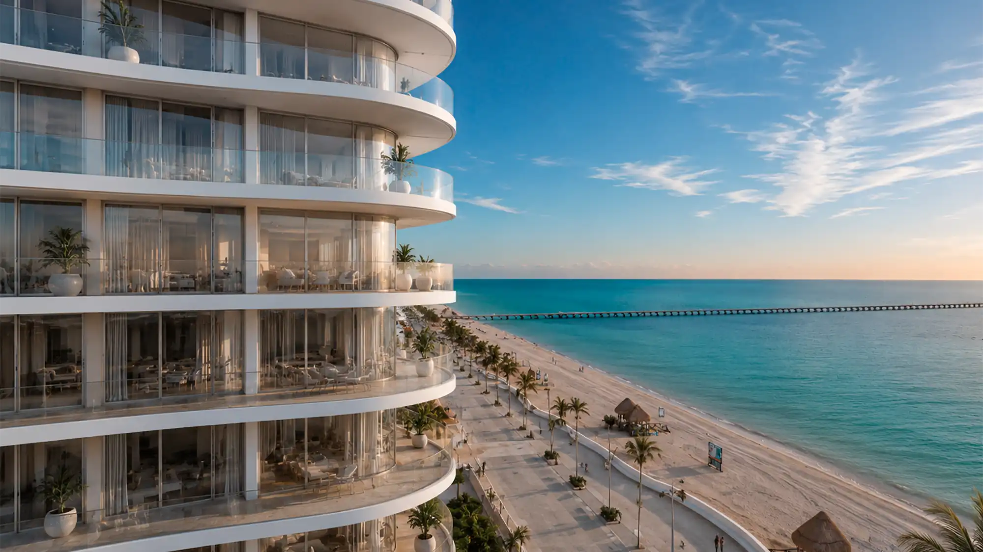 Ikonic Tower sobre el malecón de Progreso, con la playa, las palmeras y el muelle al fondo